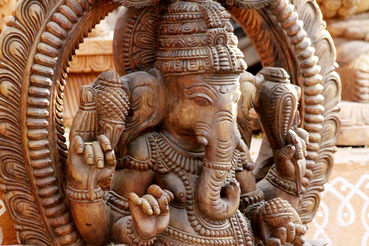 Detailed close-up of an intricately carved wooden Ganesha sculpture showcasing Indian artistry.